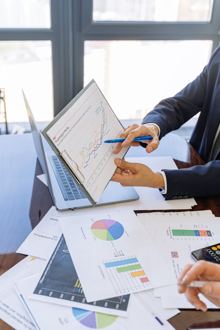 our-story Business professionals discussing financial graphs and charts in an office setting.
