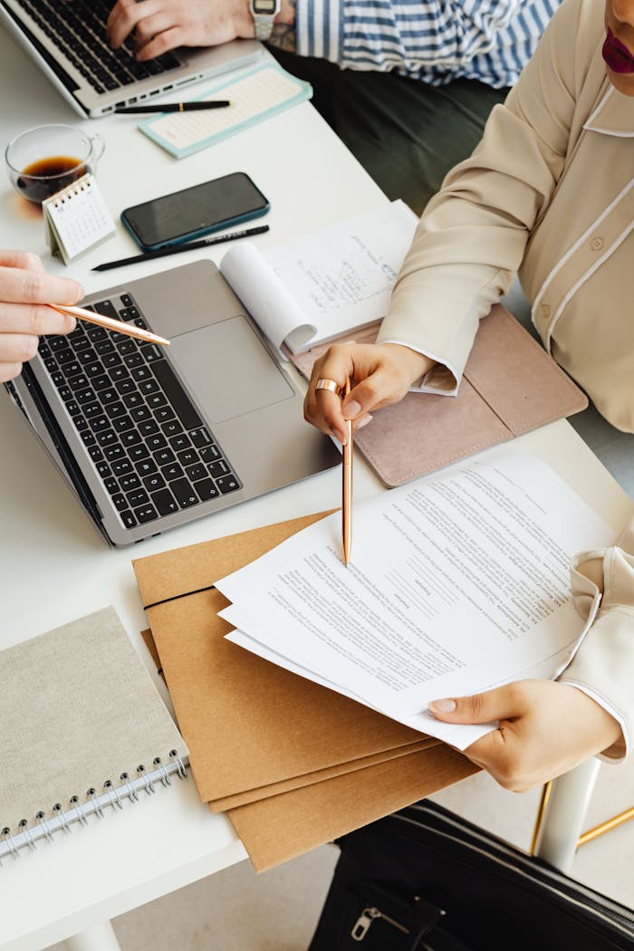 Mastering the First Impression: Your intriguing post title goes here Top view of colleagues working together with a laptop and documents in an office setting.